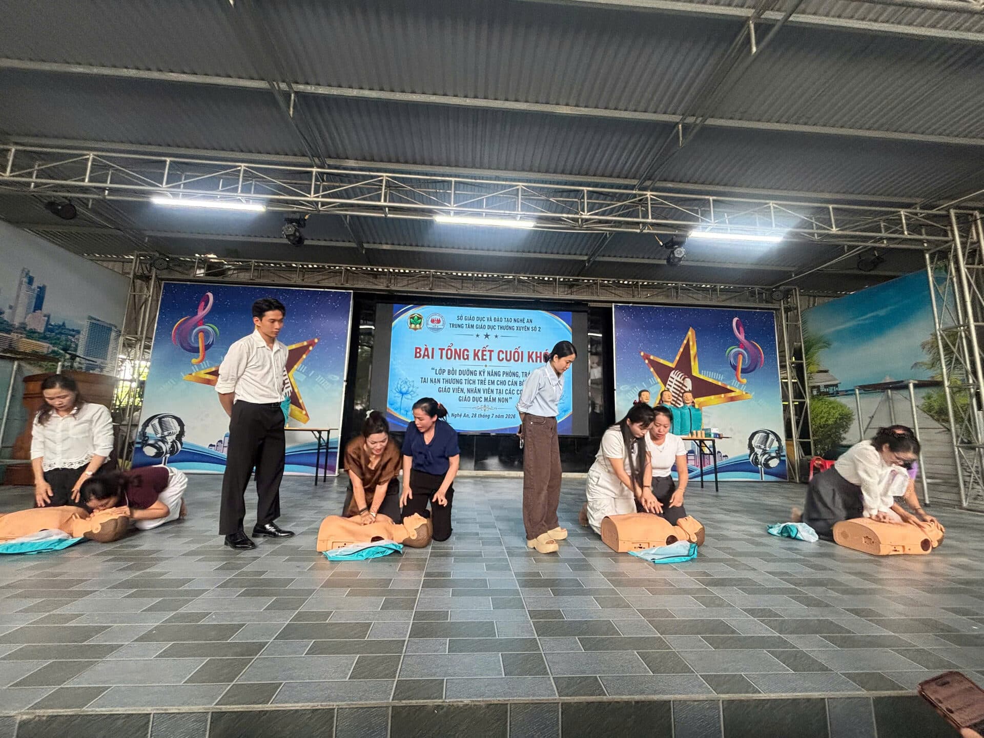 Toàn cảnh sân khấu buổi tổng kết cuối khóa tập huấn phòng, tránh tai nạn thương tích tại Nghệ An với các cặp giáo viên thực hành sơ cấp cứu trên mô hình